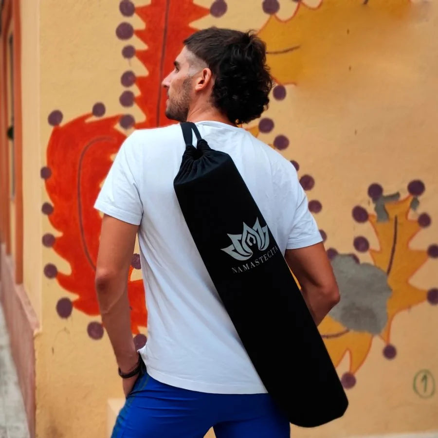 esterilla de yoga antideslizante premium guardada en bolsa de transporte de tela negra con logo blanco