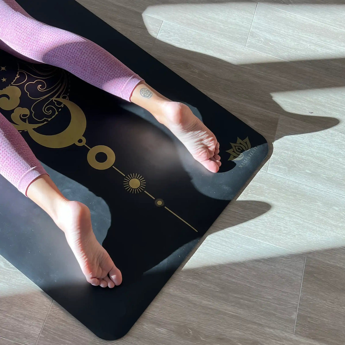 práctica de yoga sobre esterilla viajera antideslizante premium  Namastecita diseño energia negro con tinta dorada