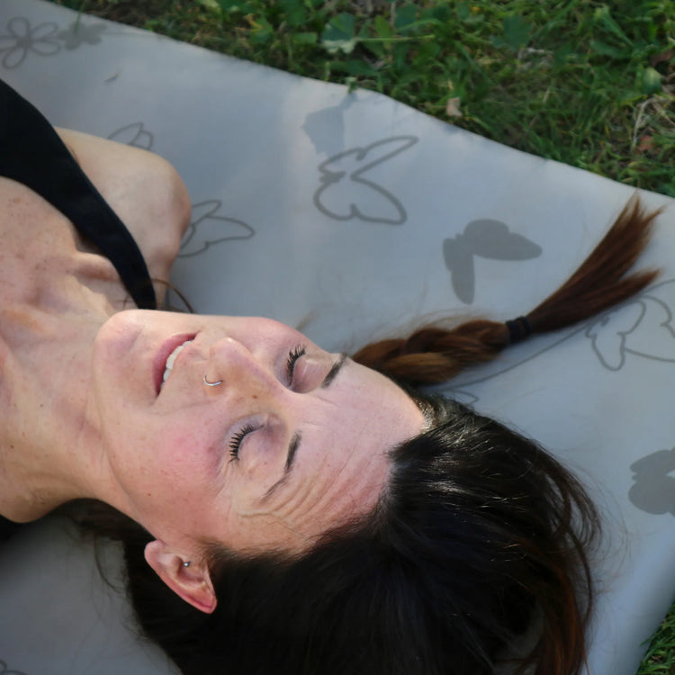 mujer relajada sobre esterilla de yoga para meditación